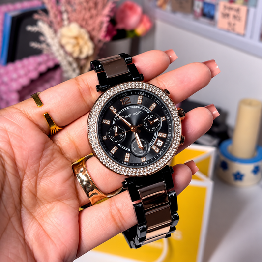 MK Parker Black Gold women's watch held in hand, black dial with crystal-set bezel